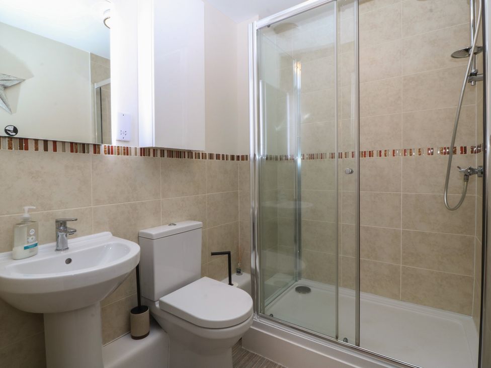 A bathroom with a shower, toilet, and sink at 2 Ocean View Colwyn Bay