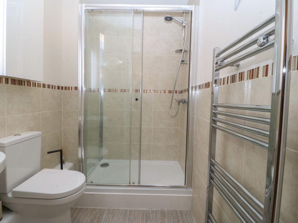 A bathroom with a shower and toilet at 2 Ocean View Colwyn Bay