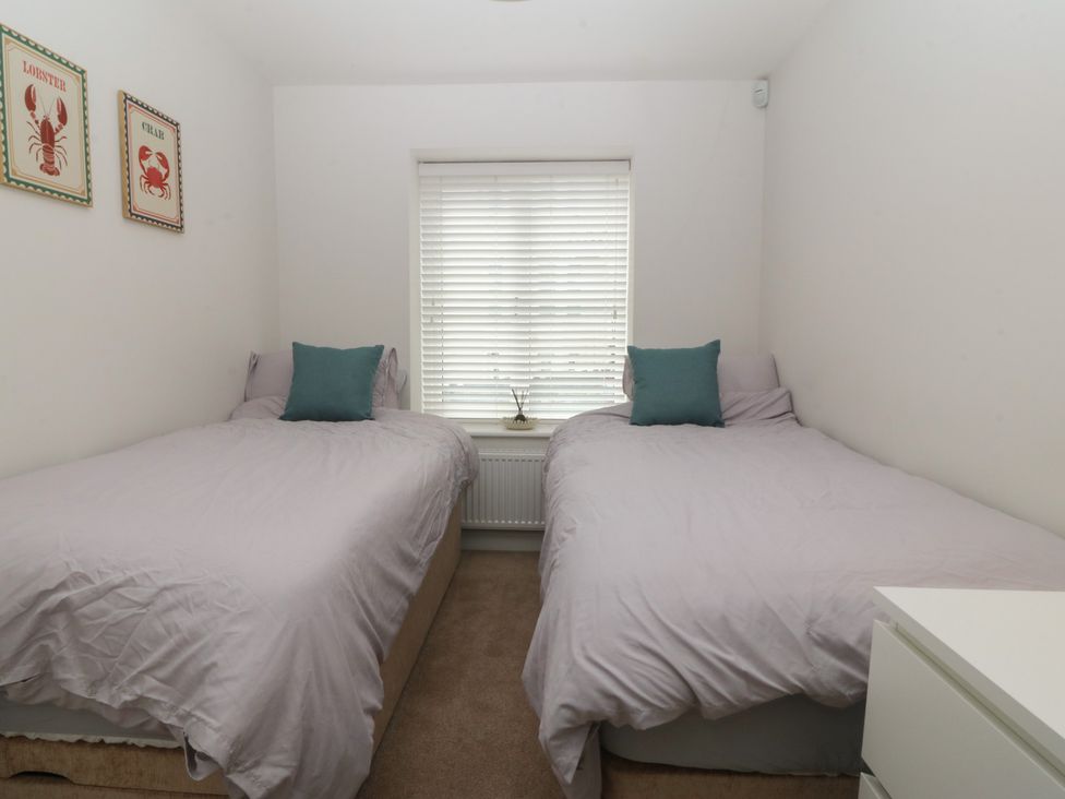 A bedroom with two beds and a window at 2 Ocean View Colwyn Bay