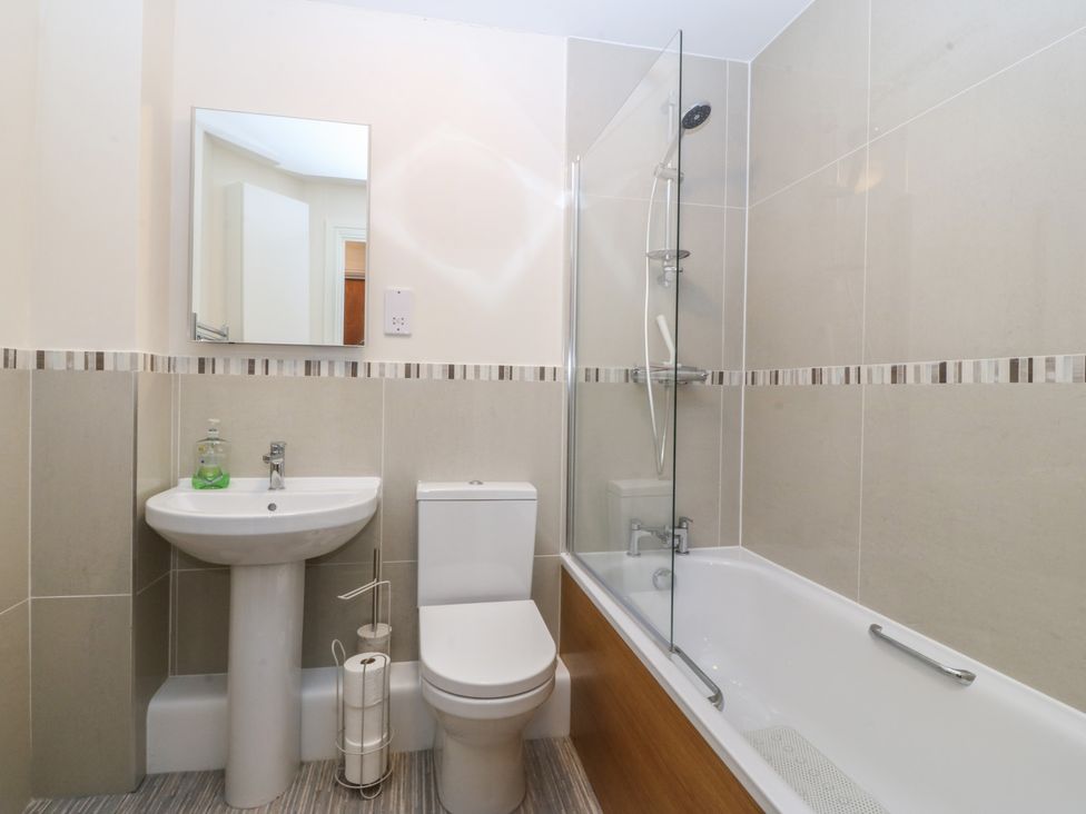 A bathroom with a sink, toilet, shower, and bathtub at 2 Ocean View in Colwyn Bay