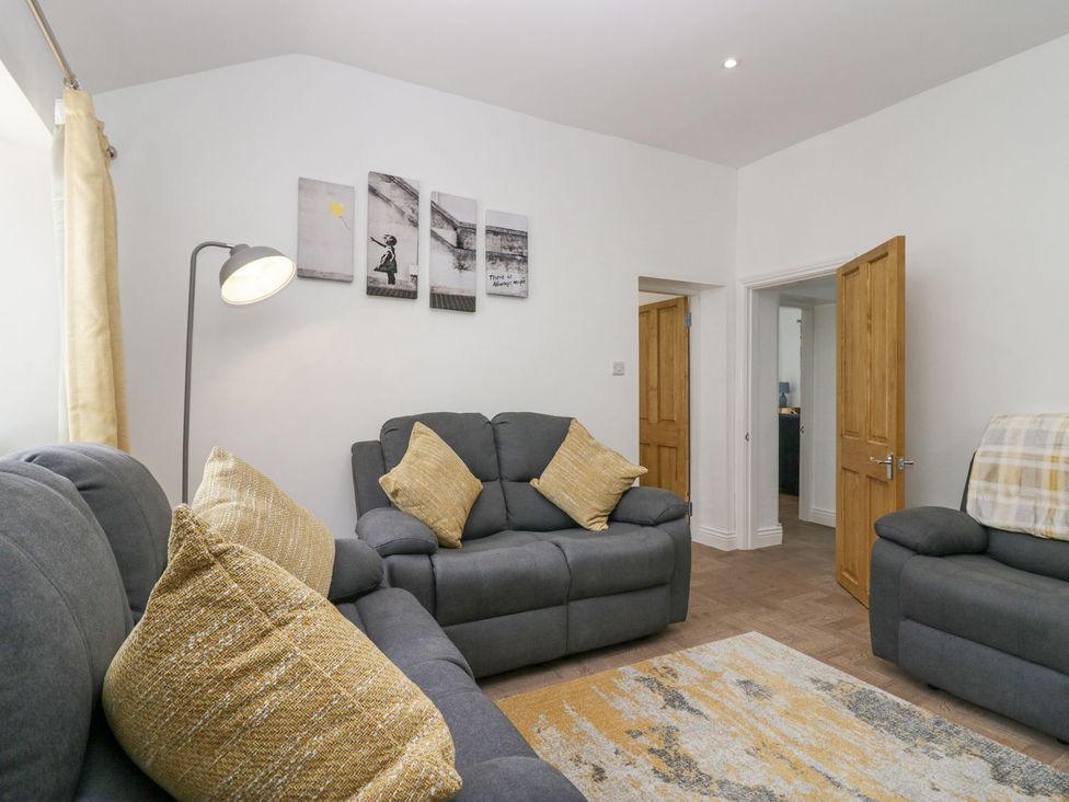 A living room with sofas and artwork on the wall at Victroneen Cottage in Whitehaven
