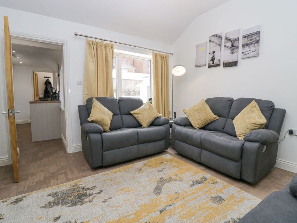 A living room with sofas and a rug at Victroneen Cottage in Whitehaven