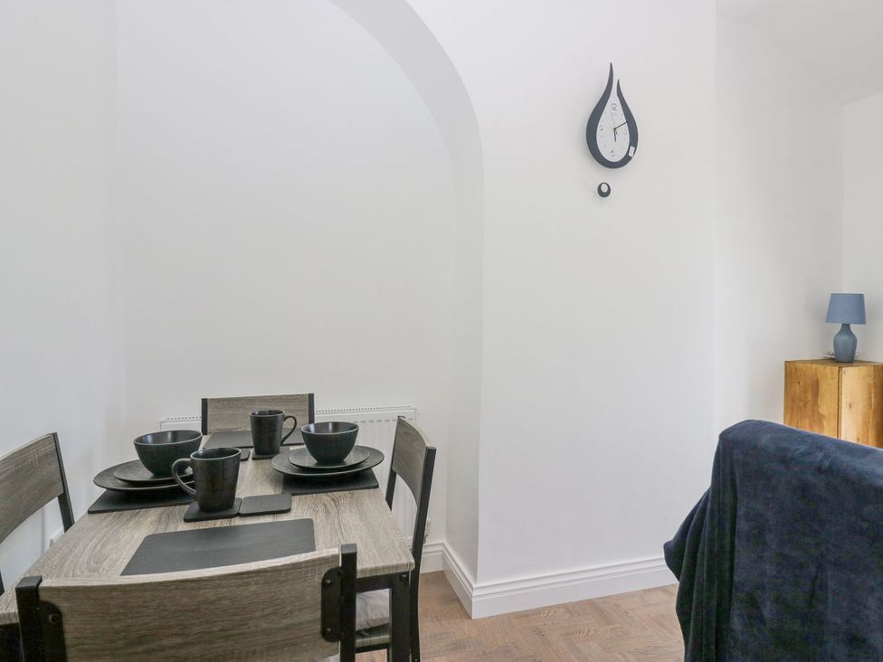 A dining room with table and dinnerware at Victroneen Cottage in Whitehaven