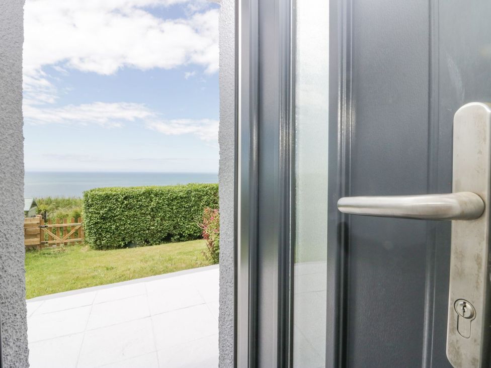 A view from a door opening to the ocean at Victroneen Cottage Whitehaven