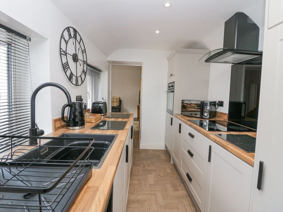 A kitchen with appliances and sink at Victroneen Cottage Whitehaven