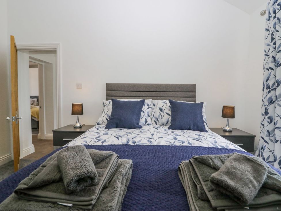 A bedroom with a bed and bedside lamps at Victroneen Cottage Whitehaven