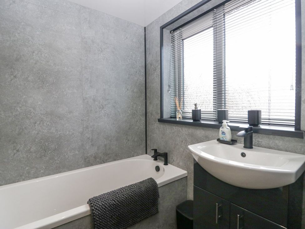 A bathroom with a bathtub and sink at Victroneen Cottage Whitehaven