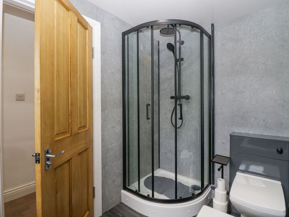 A bathroom with a shower, toilet, and sink at Victroneen Cottage in Whitehaven