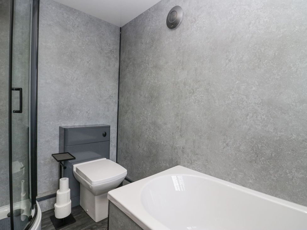 A bathroom with a shower, toilet, and bathtub at Victroneen Cottage Whitehaven