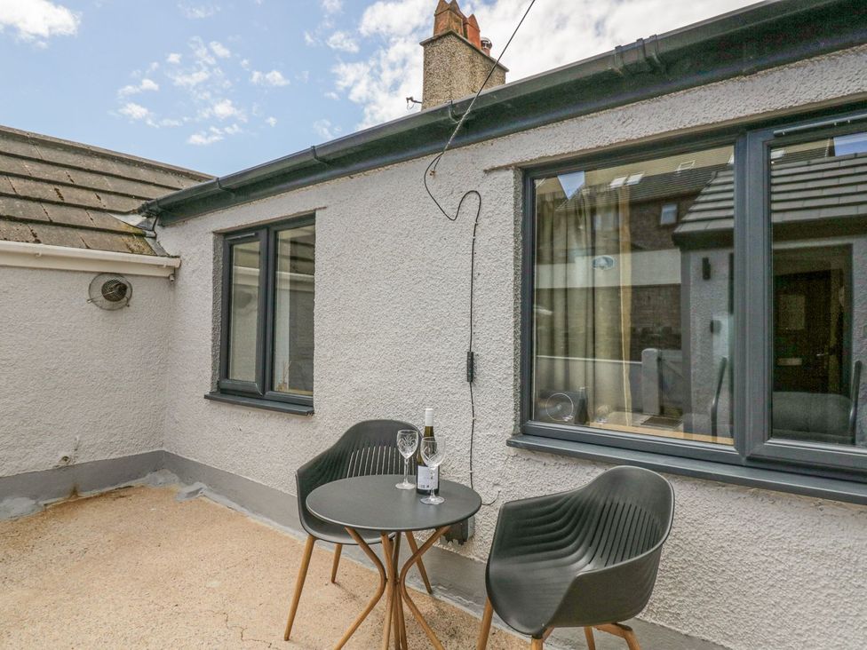 An outdoor seating area with a table and chairs at Victroneen Cottage Whitehaven