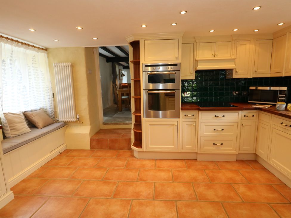 A kitchen with cabinets and appliances at Rose Cottage in Osmington