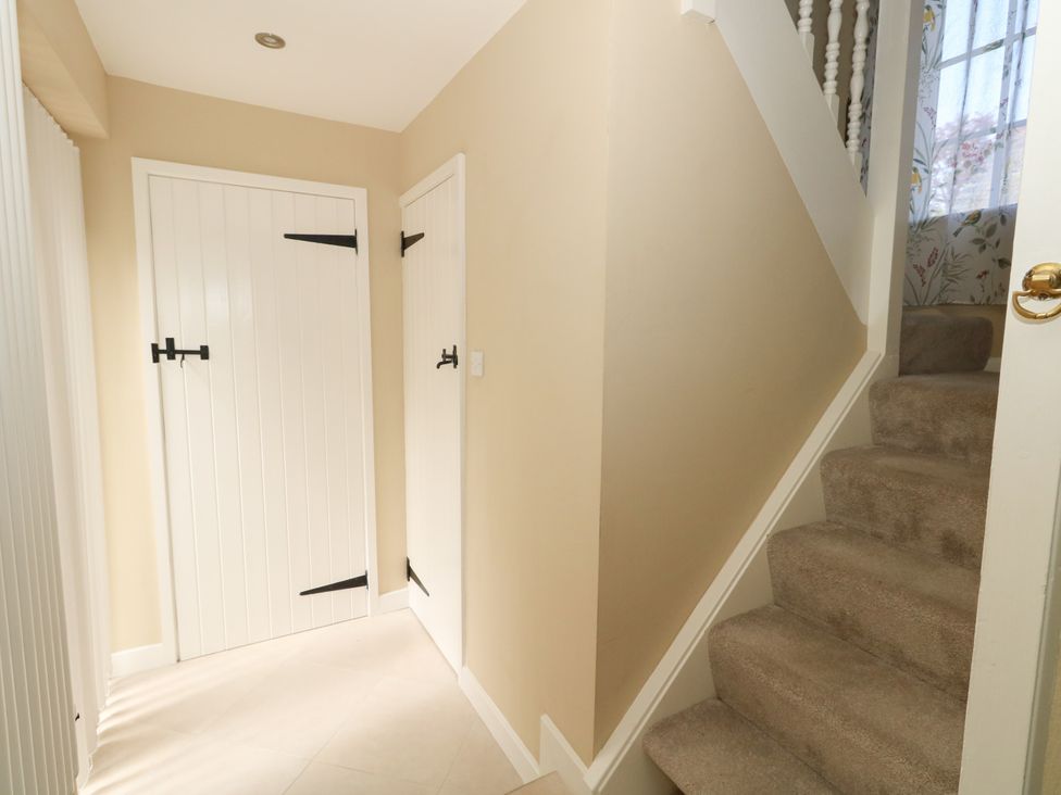 A hallway with two doors and stairs at Rose Cottage in Osmington