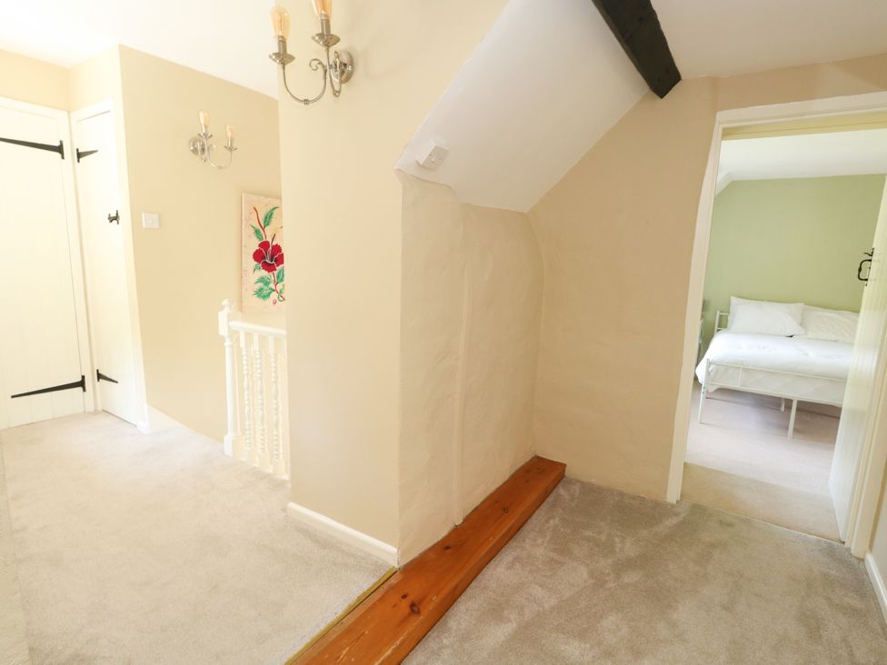 A hallway with stairs and doors at Rose Cottage in Osmington