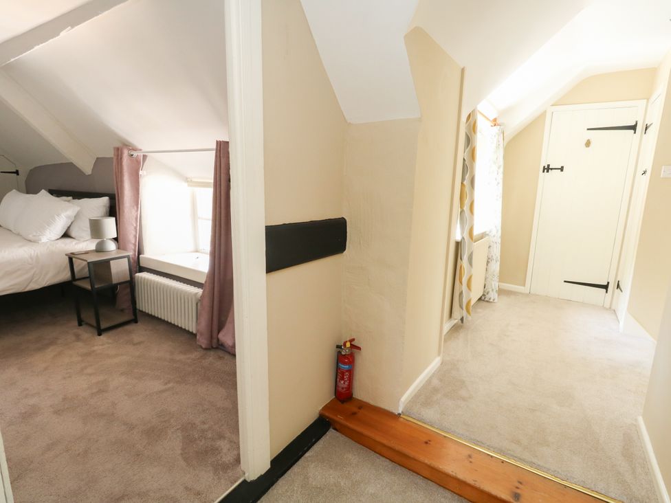 A bedroom with a bed and nightstand at Rose Cottage in Osmington