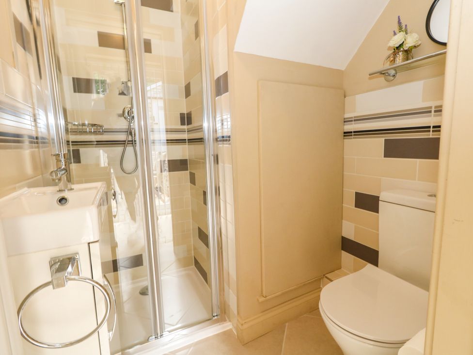 A bathroom with a shower, toilet, and sink at Rose Cottage in Osmington
