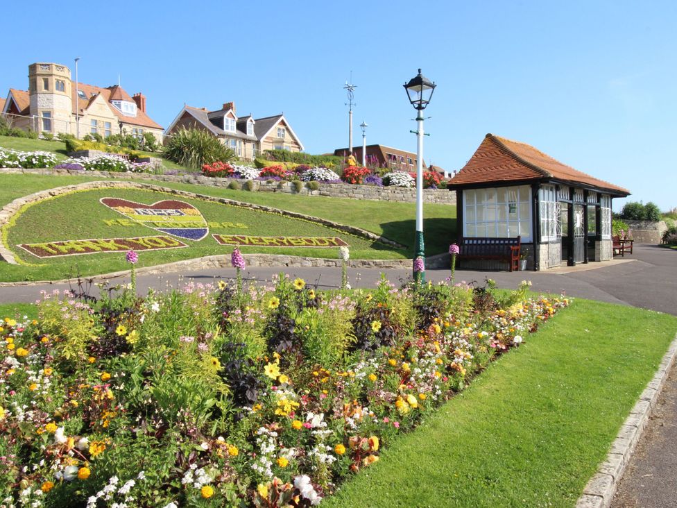 A flowerbed and a seating area at Rose Cottage in Osmington