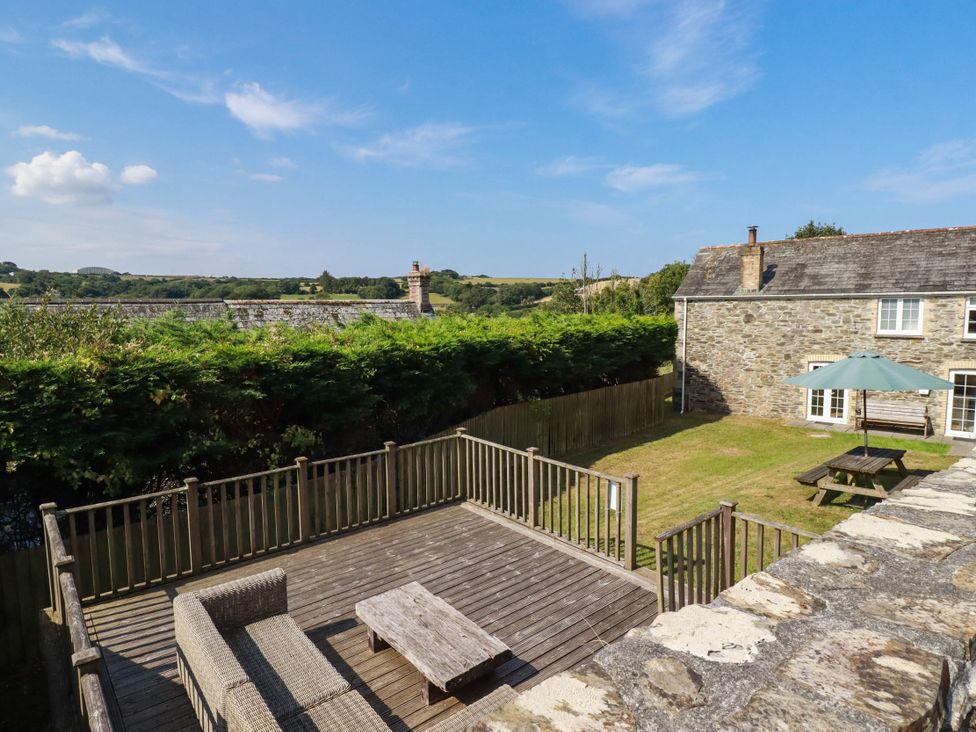 An outdoor area with a deck and furniture at Bryher Cottage in St Mawgan