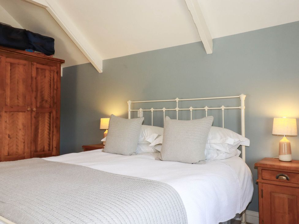 A bedroom with a bed and bedside tables at Bryher Cottage in St Mawgan