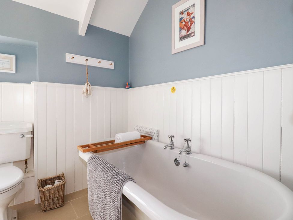 A bathroom with a bathtub and toilet at Bryher Cottage St Mawgan