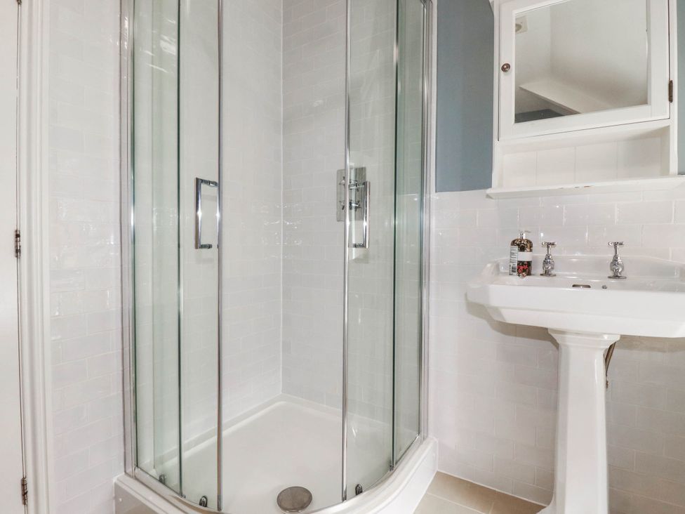 A bathroom with a shower and sink at Bryher Cottage St Mawgan