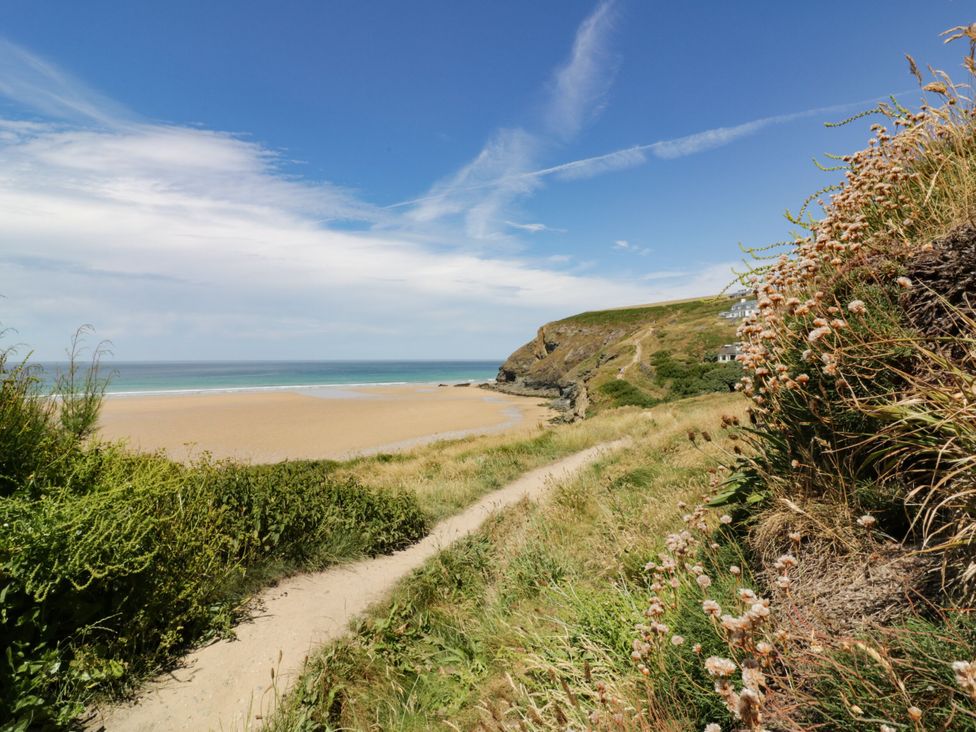 A beach with a path leading to the ocean at Bryher Cottage in St Mawgan