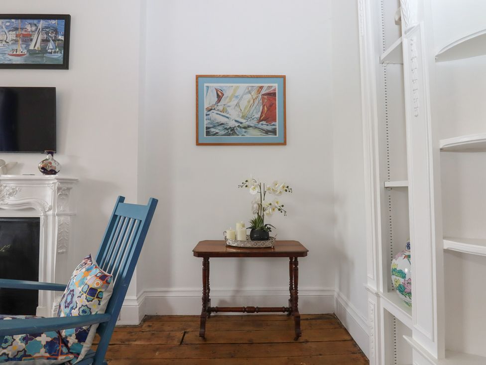 A living room with a table and television at Marina Court Apartment in Torquay