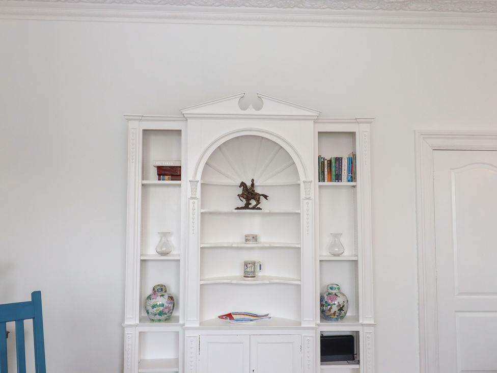 A bookcase with decorative items in Marina Court Apartment Torquay