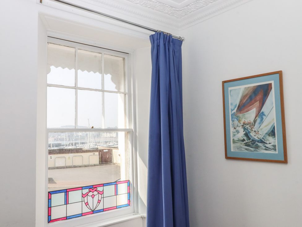 A room with a window showing sailboats and a painting at Marina Court Apartment in Torquay