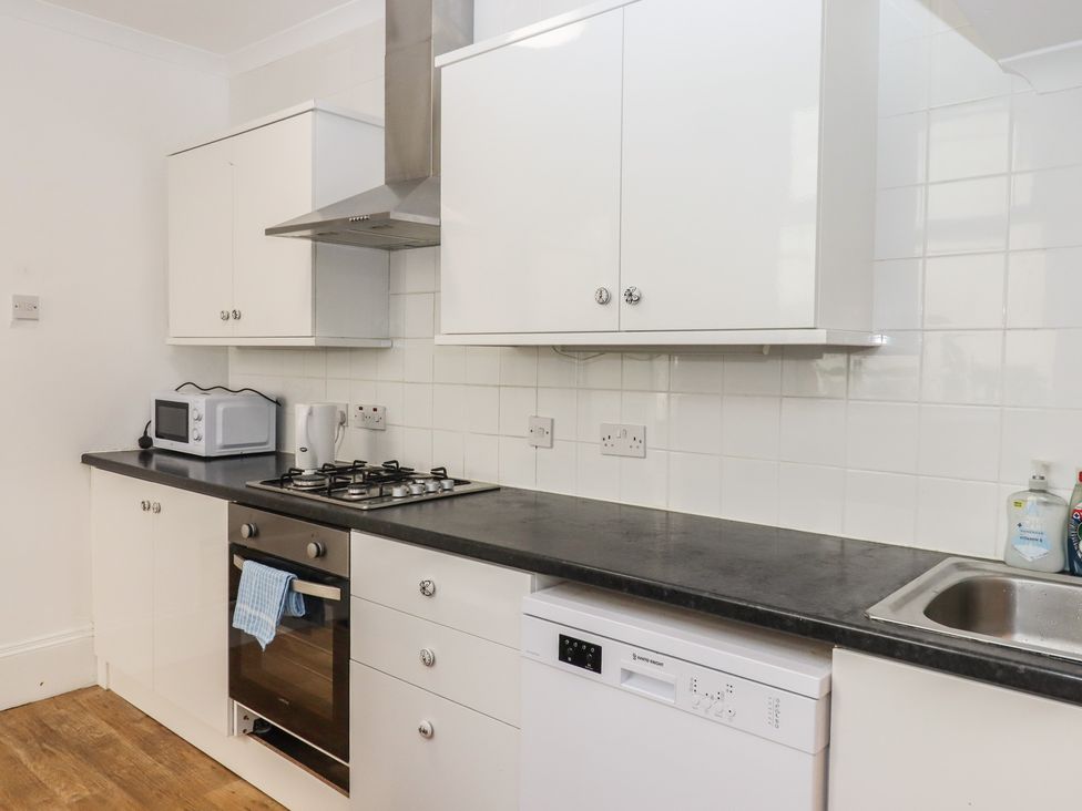 A kitchen with appliances including a microwave and oven at Marina Court Apartment in Torquay