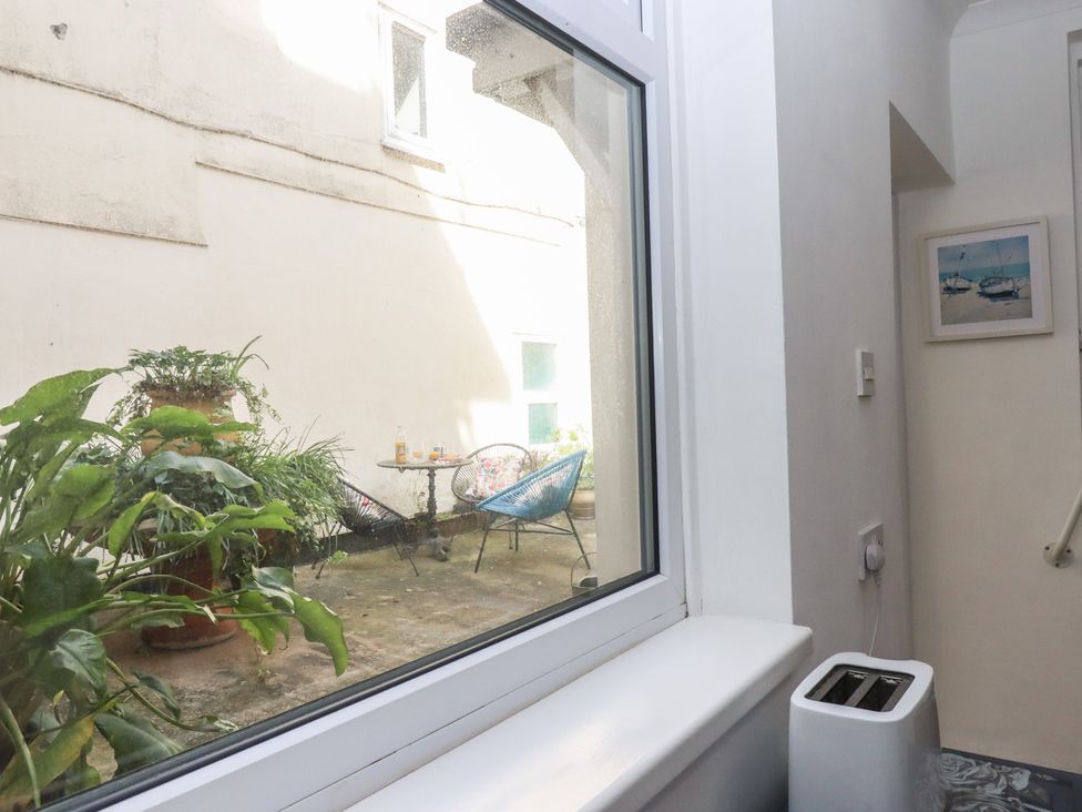 A view of a courtyard with plants and furniture at Marina Court Apartment in Torquay