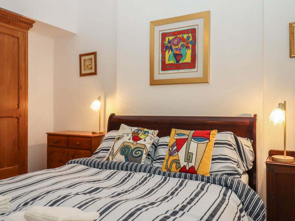 A bedroom with a bed and art on the wall at Marina Court Apartment Torquay