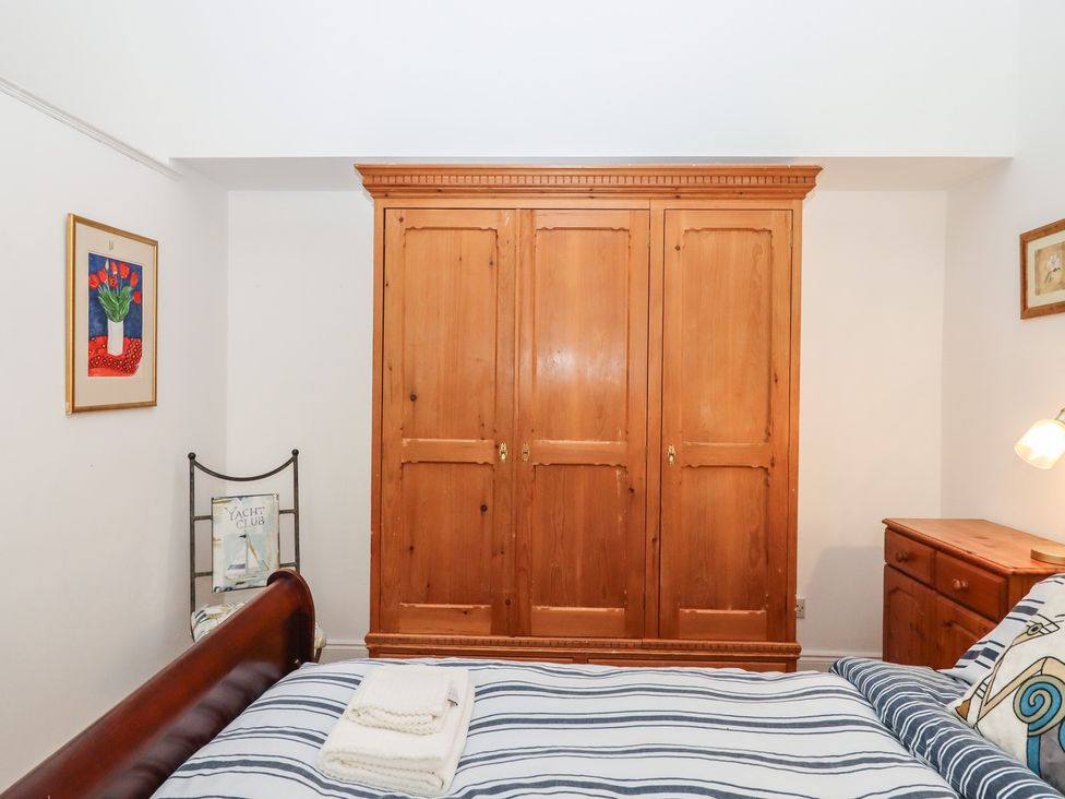 A bedroom with a bed and wardrobe at Marina Court Apartment Torquay
