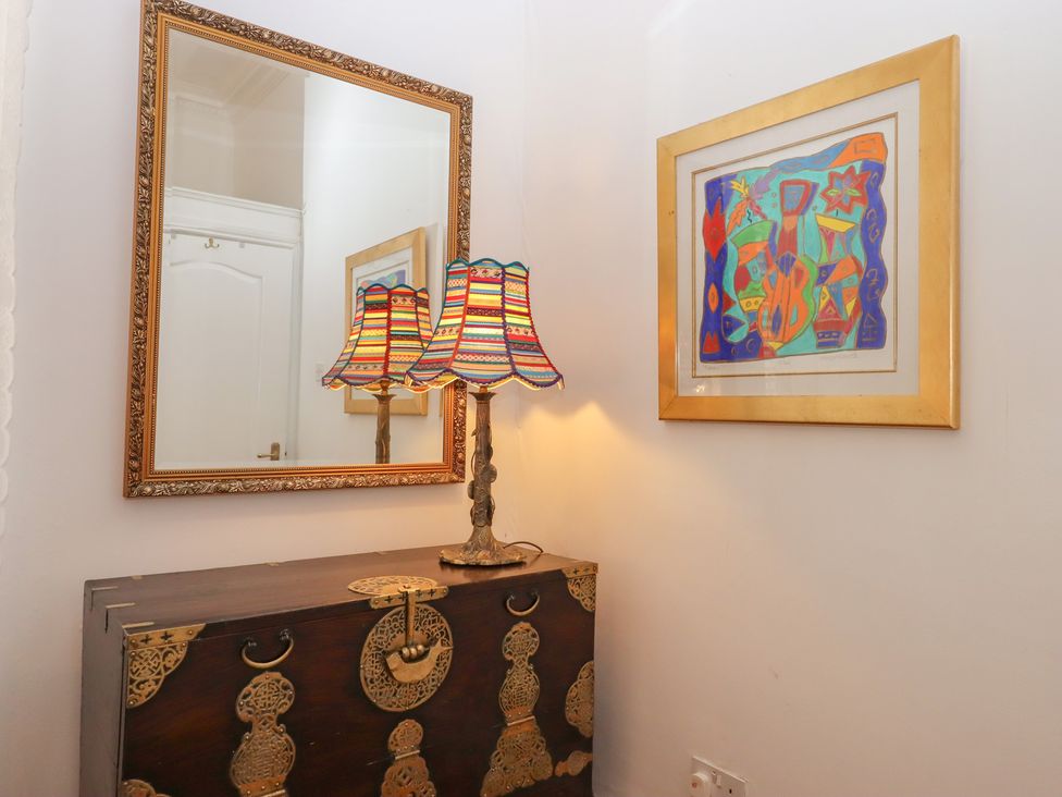 A hallway with a lamp and artwork at Marina Court Apartment in Torquay