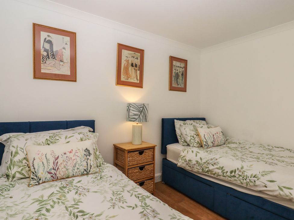 A bedroom with two beds and wall art at Marina Court Apartment in Torquay