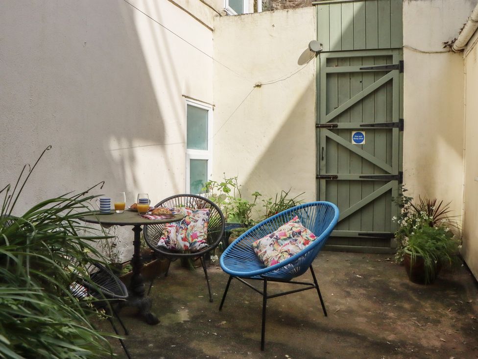 An outdoor area with chairs and a table at Marina Court Apartment Torquay