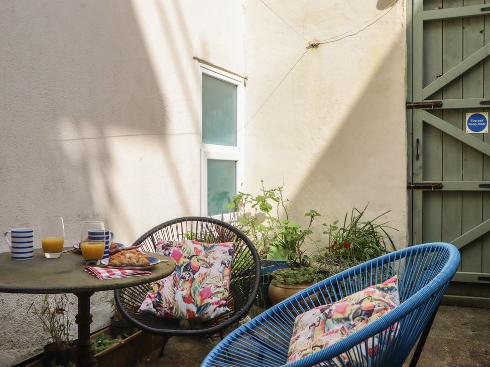 An outdoor seating area with a table and chairs at Marina Court Apartment in Torquay