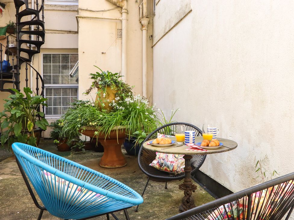 A garden with a table and chairs at Marina Court Apartment in Torquay
