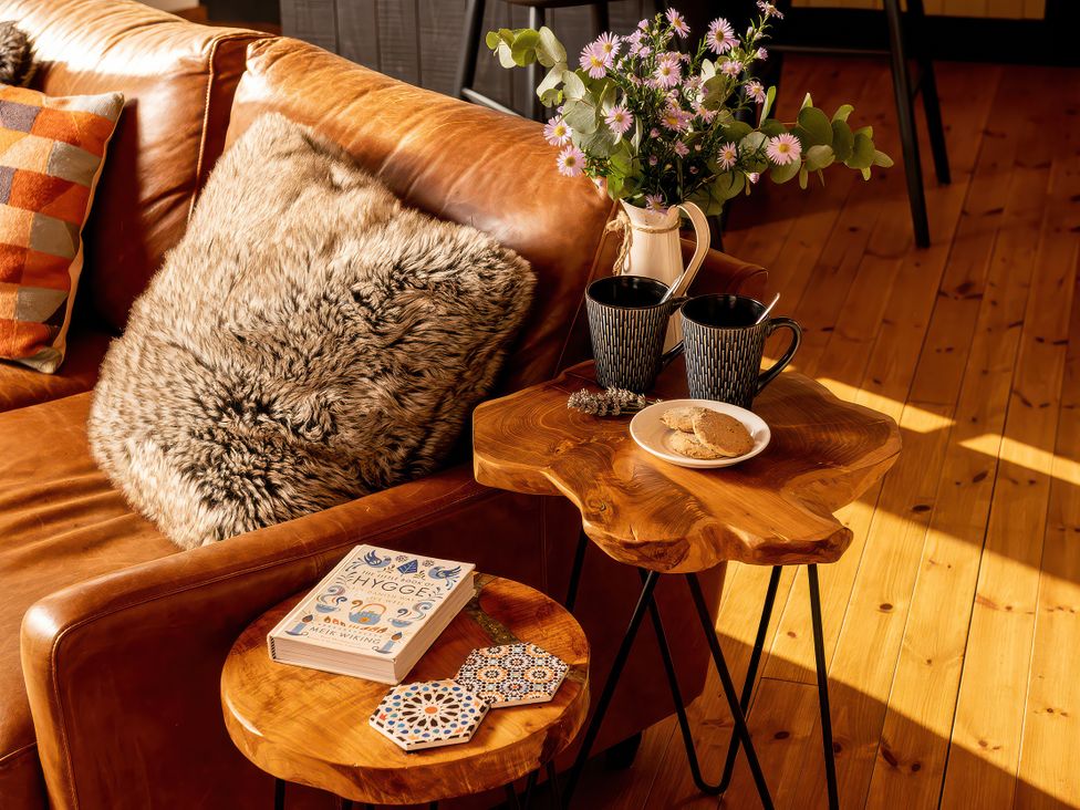 A living room with a sofa and a coffee table at Cwtch Log Cabin Llandrillo