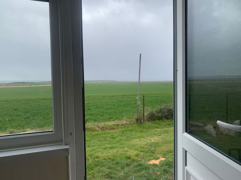 A view from a window showing grass and a fence at Watersmeet - 85 @ Park Avenue Holiday Village Leysdown-On-Sea, Kent