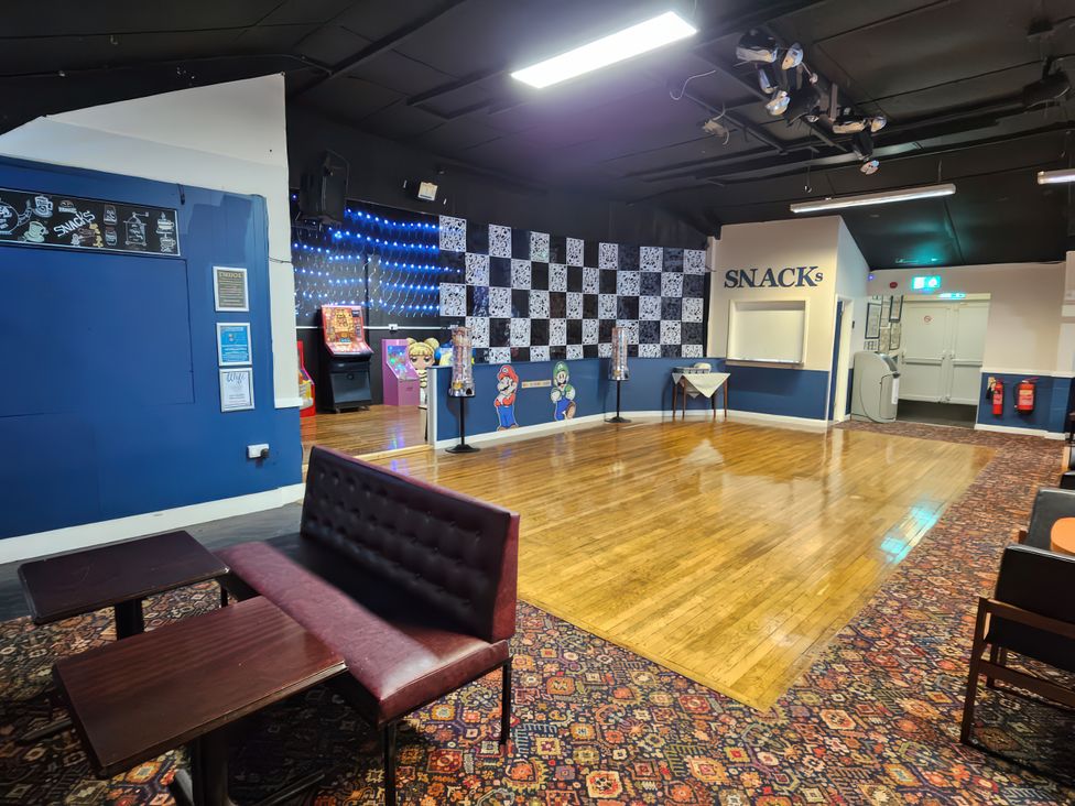 A game room with seating and arcade machines at Watersmeet - 85 @ Park Avenue Holiday Village Leysdown-On-Sea, Kent