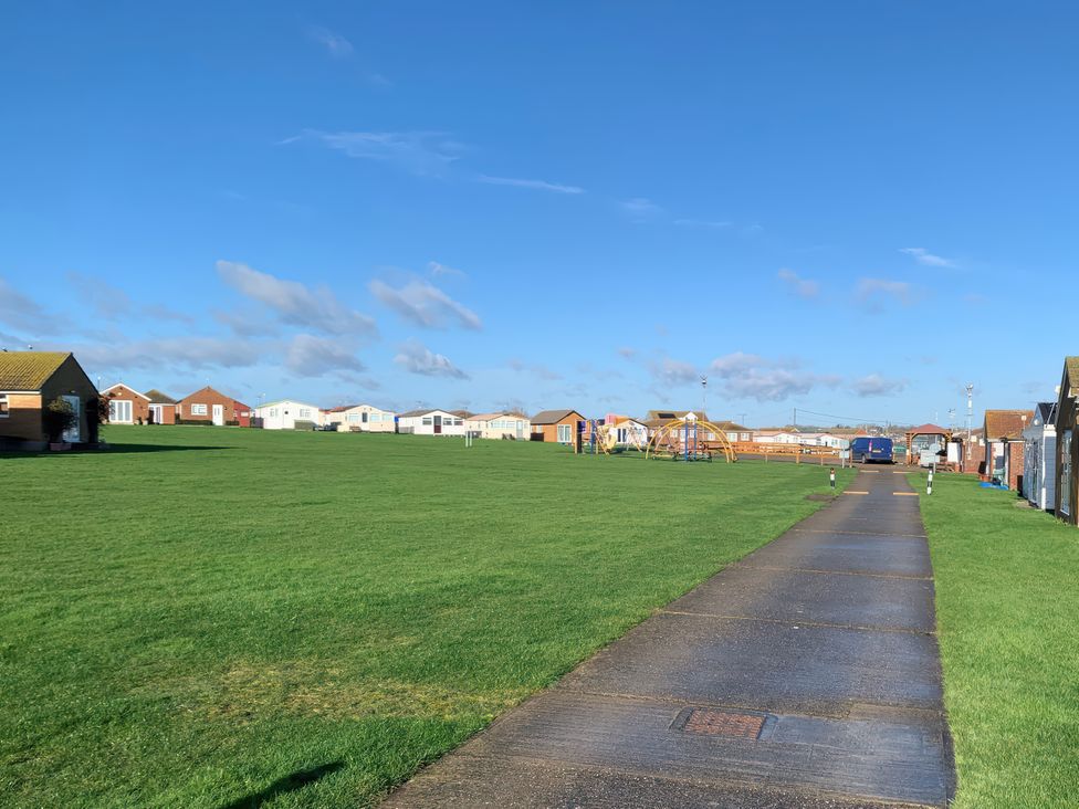 An outdoor area with mobile homes and a pathway at Watersmeet - 85 @ Park Avenue Holiday Village, Leysdown-On-Sea, Kent