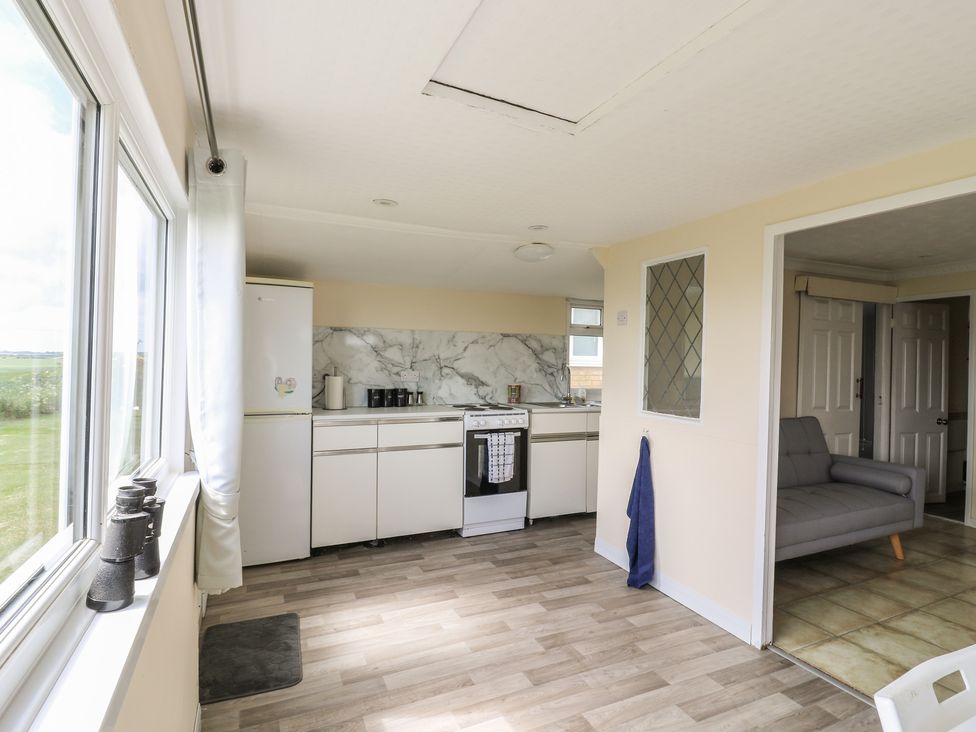A kitchen with countertop and refrigerator at Watersmeet - 85 @ Park Avenue Holiday Village in Leysdown-On-Sea, Kent