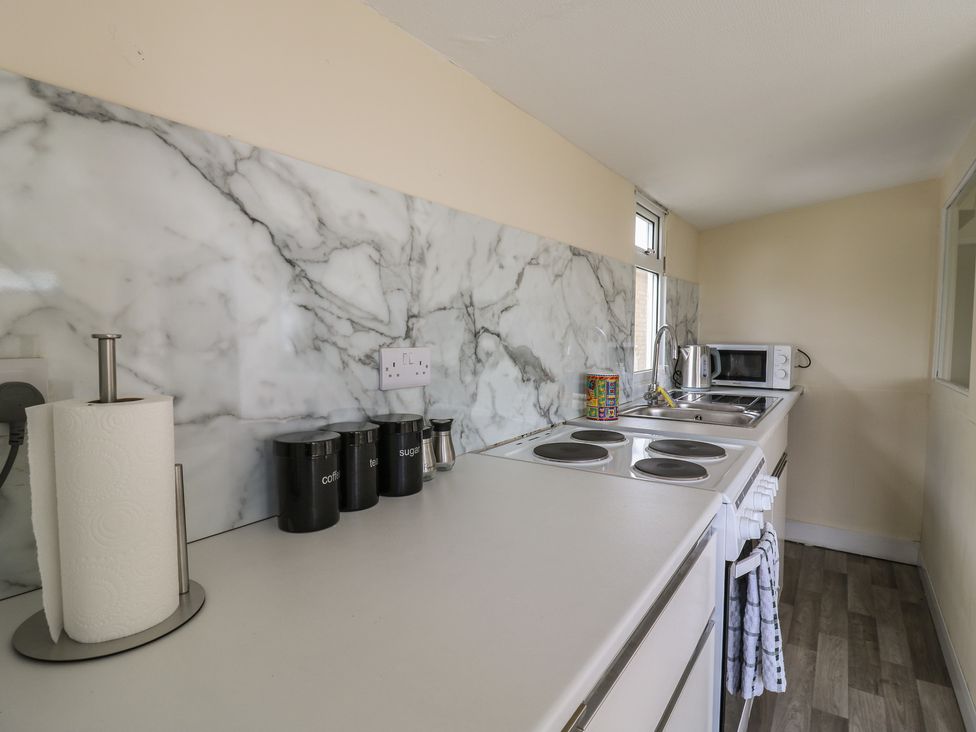 A kitchen with appliances and countertop features at Watersmeet - 85 @ Park Avenue Holiday Village, Leysdown-On-Sea, Kent