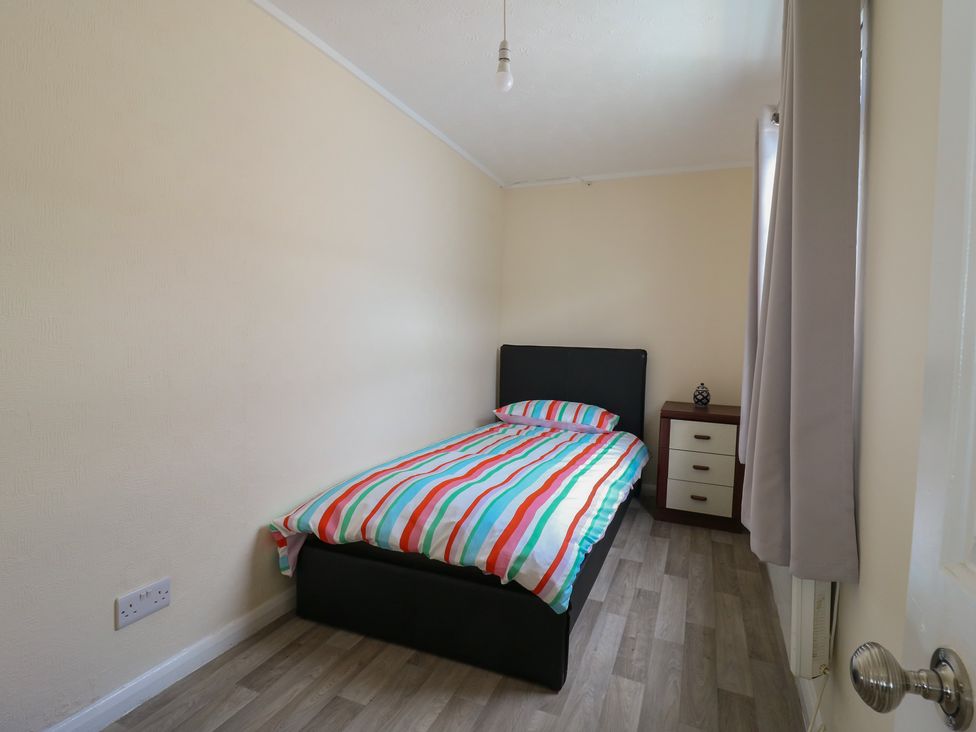 A bedroom with a bed and nightstand at Watersmeet - 85 @ Park Avenue Holiday Village, Leysdown-On-Sea, Kent