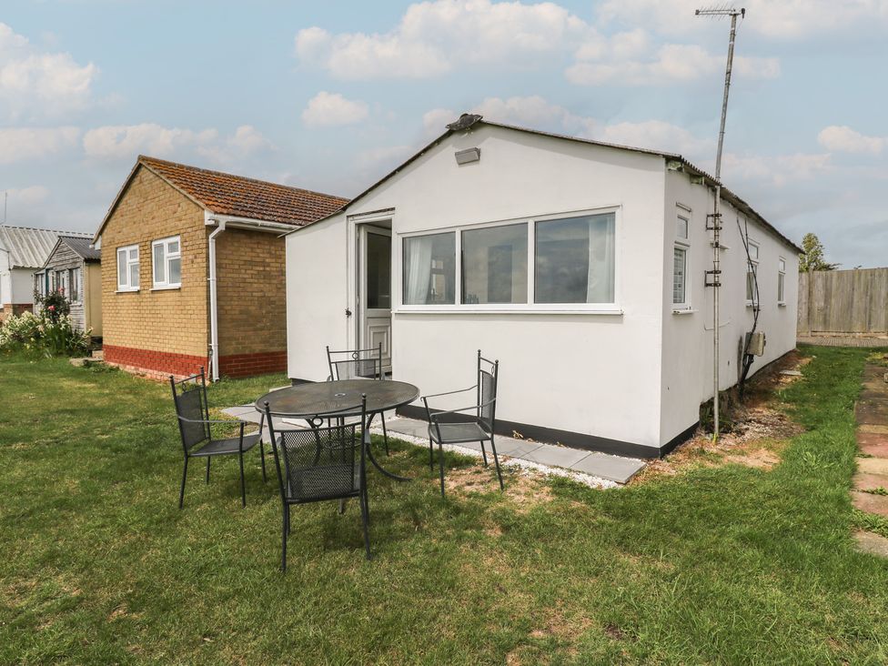 A house with a table and chairs on grass at Watersmeet - 85 @ Park Avenue Holiday Village, Leysdown-On-Sea, Kent