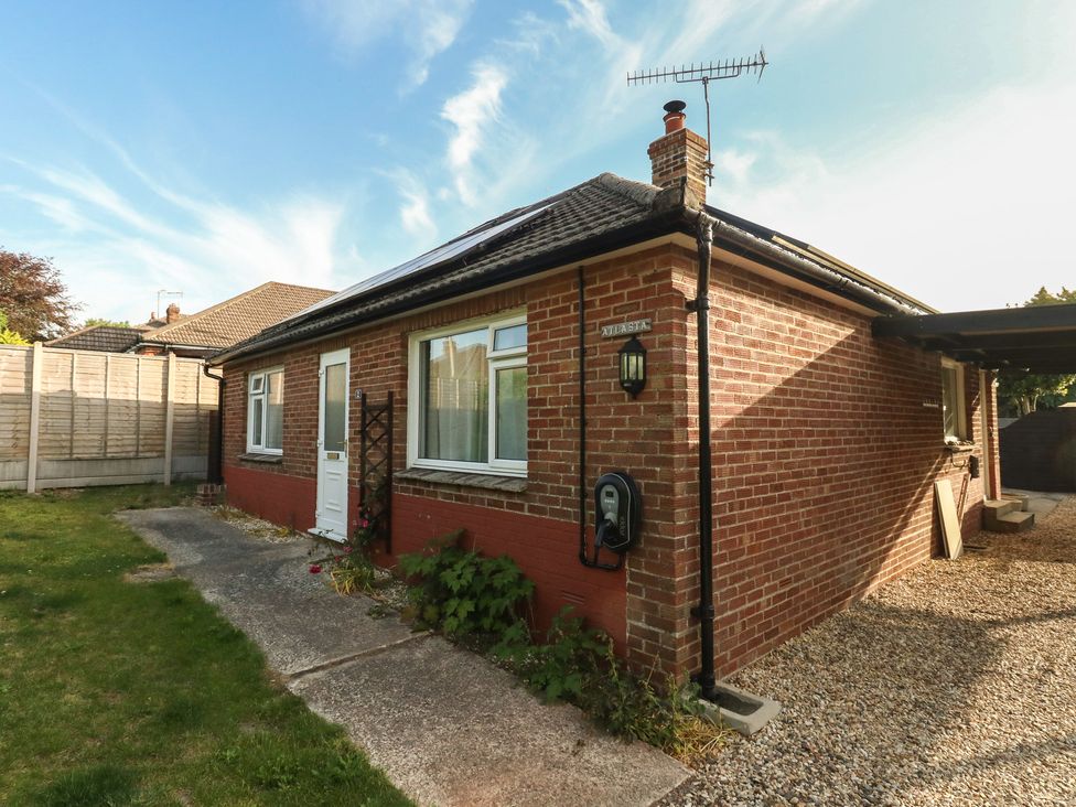 An outdoor view of a house with a driveway and garden at 2 North Road in Maiden Newton, Dorset