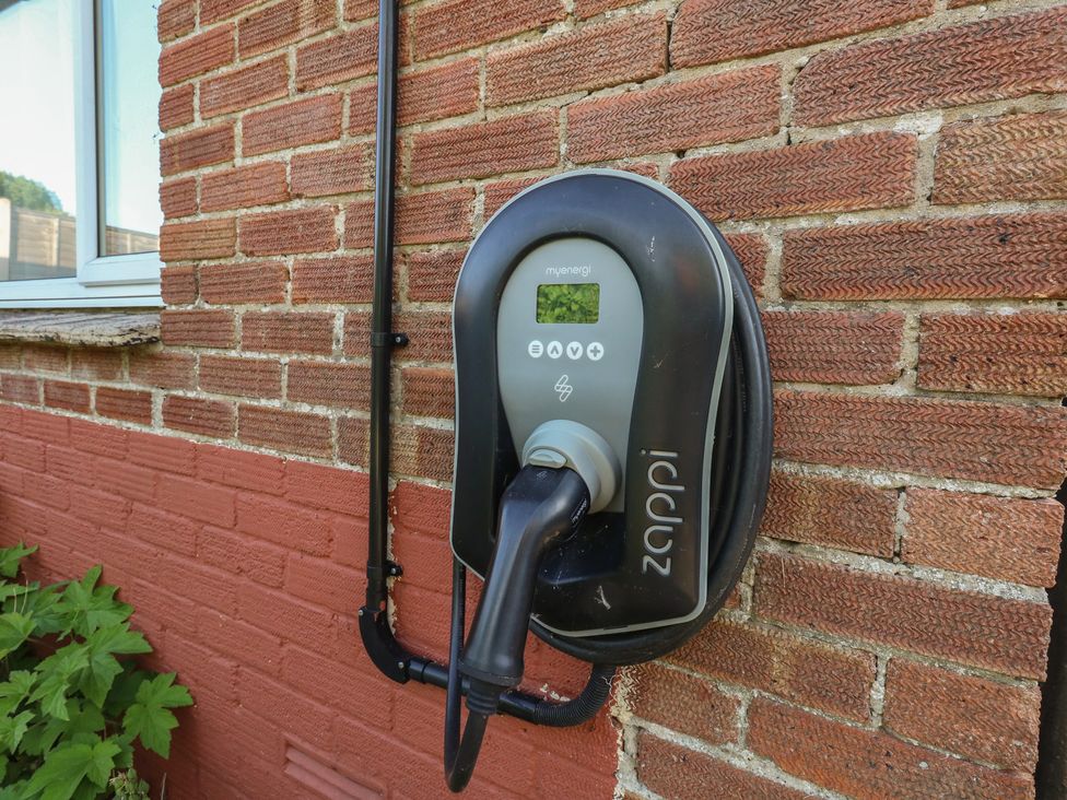 An electric vehicle charger mounted on a wall at 2 North Road in Maiden Newton, Dorset
