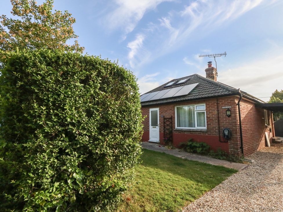 A house with solar panels and a bush at 2 North Road Maiden Newton Dorset
