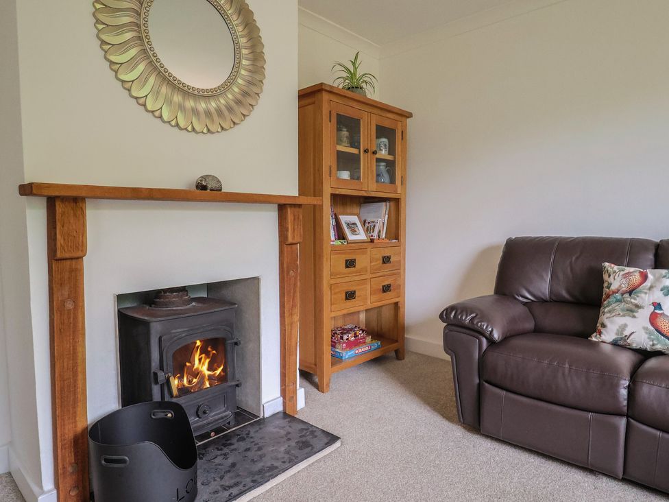 A living room with a fireplace and cabinet at 2 North Road, Maiden Newton, Dorset
