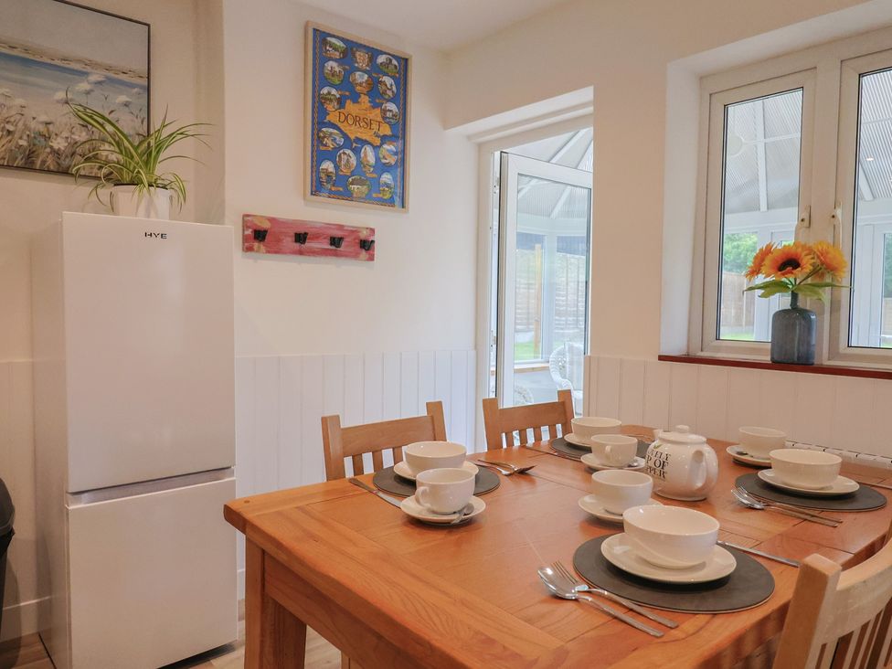 A dining room with a table set for meal at 2 North Road Maiden Newton Dorset